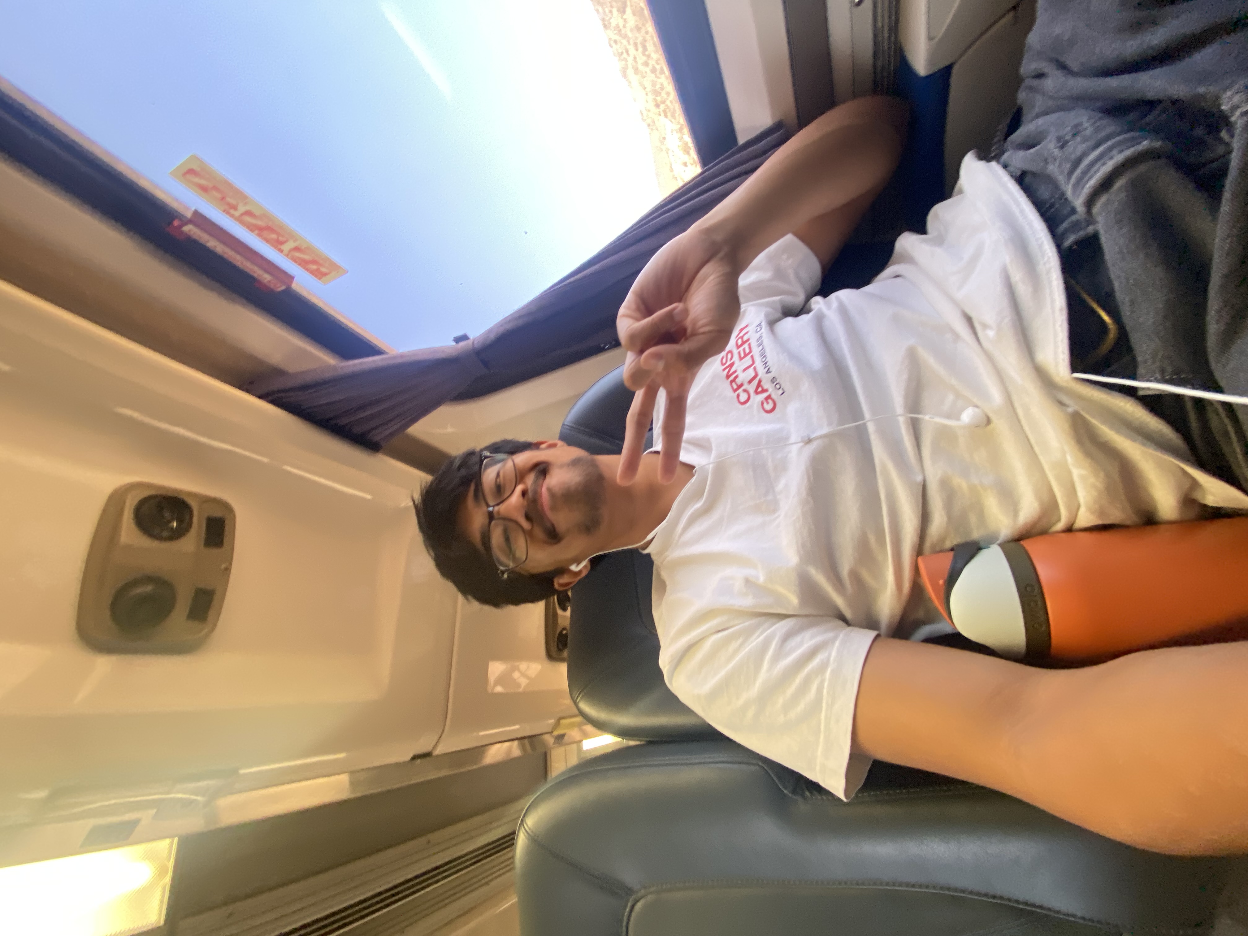 Piolo on a train. Holding up a peace sign and smiling. No visible text in the image.